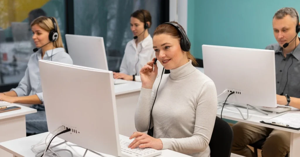 Équipe de service client avec casques téléphoniques, travaillant devant des ordinateurs dans un open space